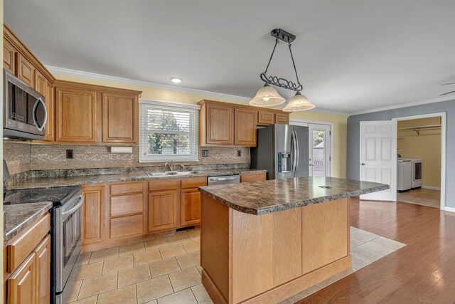 135 Carter Rd, Winchester, TN 37398 - kitchen featuring appliances with stainless steel finishes, dark countertops, a sink, washing machine and clothes dryer, and healthy amount of natural light