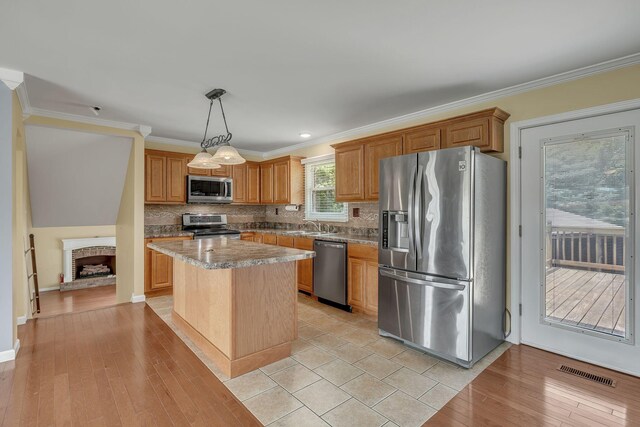 135 Carter Rd, Winchester, TN 37398 - kitchen featuring appliances with stainless steel finishes, a center island, a sink, tasteful backsplash, and crown molding