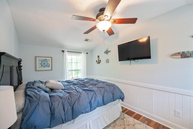 91 Creekside View Ln, Decaturville, TN 38329 - bedroom with wood finished floors, a wainscoted wall, a ceiling fan, and vaulted ceiling