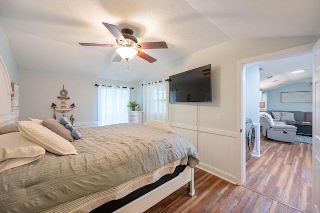 91 Creekside View Ln, Decaturville, TN 38329 - bedroom with vaulted ceiling, wood finished floors, a wainscoted wall, washer and dryer, and a ceiling fan