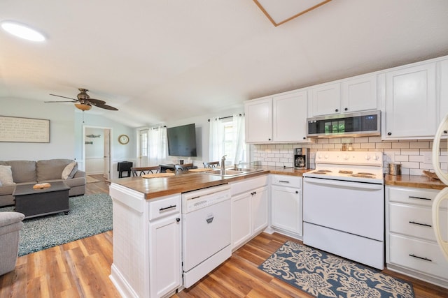 91 Creekside View Ln, Decaturville, TN 38329 - kitchen featuring white appliances, a sink, open floor plan, a peninsula, and vaulted ceiling