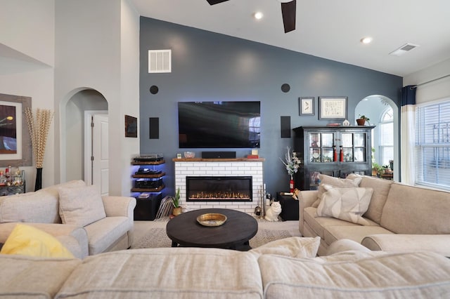 2844 Bluestem Ln, Murfreesboro, TN 37128 - living area featuring high vaulted ceiling, arched walkways, a ceiling fan, a brick fireplace, and recessed lighting
