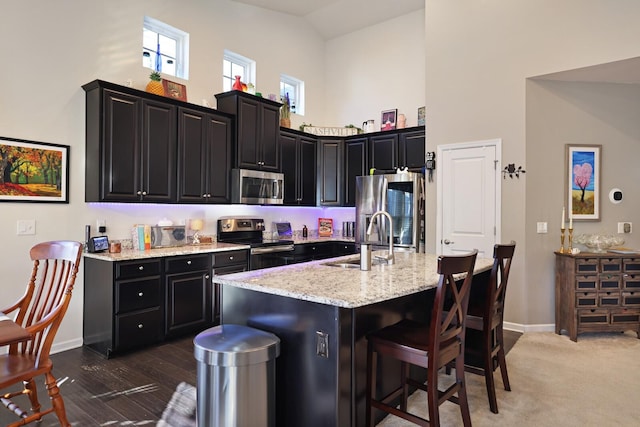 2844 Bluestem Ln, Murfreesboro, TN 37128 - kitchen with stainless steel appliances, a sink, dark cabinetry, high vaulted ceiling, and baseboards