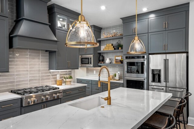 7286 Murrel Dr, Franklin, TN 37064 - kitchen featuring stainless steel appliances, tasteful backsplash, light stone counters, custom range hood, and hanging light fixtures