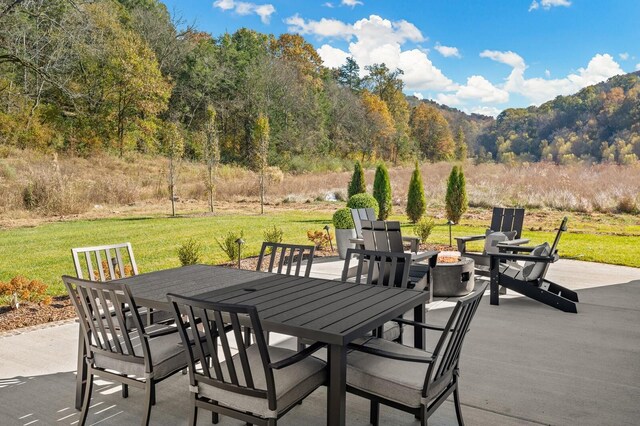 7286 Murrel Dr, Franklin, TN 37064 - view of patio featuring a fire pit, outdoor dining space, and a forest view