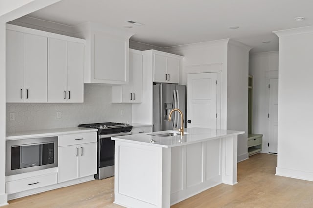 1712 Carvell Ave, Nashville, TN 37203 - kitchen featuring appliances with stainless steel finishes, a sink, light wood-type flooring, tasteful backsplash, and light countertops