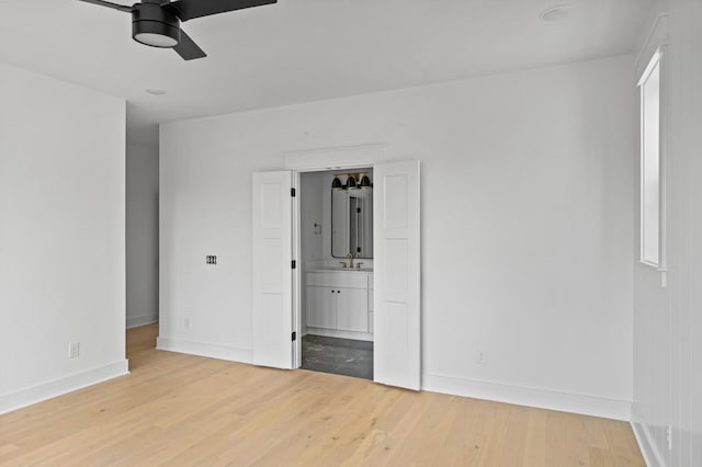 1712 Carvell Ave, Nashville, TN 37203 - unfurnished bedroom with baseboards, light wood-type flooring, connected bathroom, and a sink
