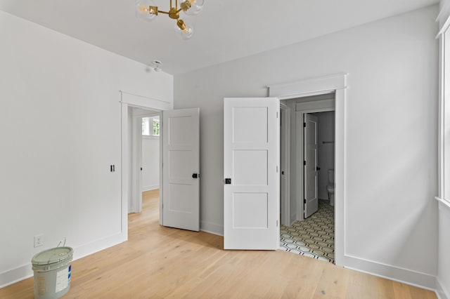 1712 Carvell Ave, Nashville, TN 37203 - unfurnished bedroom featuring a chandelier, baseboards, and light wood-style floors