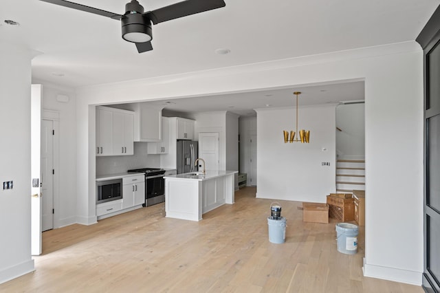 1712 Carvell Ave, Nashville, TN 37203 - kitchen featuring appliances with stainless steel finishes, ceiling fan, light wood finished floors, white cabinets, and light countertops