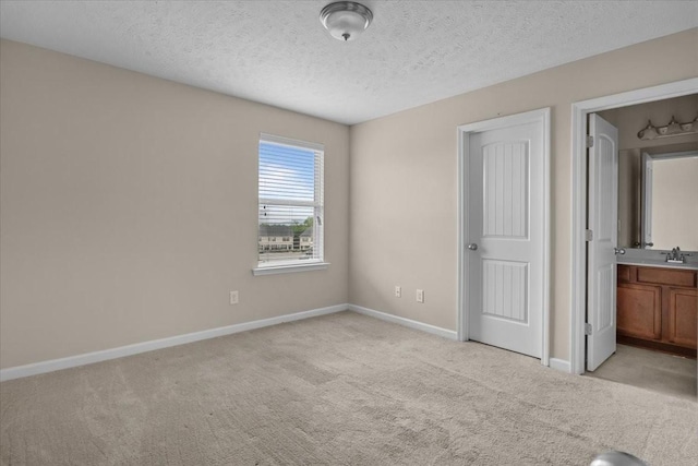 4316 Summercrest Blvd Unit 105, Antioch, TN 37013 - unfurnished bedroom featuring light colored carpet, baseboards, a textured ceiling, a sink, and connected bathroom