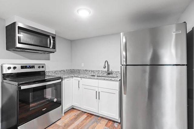 129 Neese Dr, Nashville, TN 37211 - kitchen with appliances with stainless steel finishes, a sink, light stone counters, white cabinets, and light wood finished floors