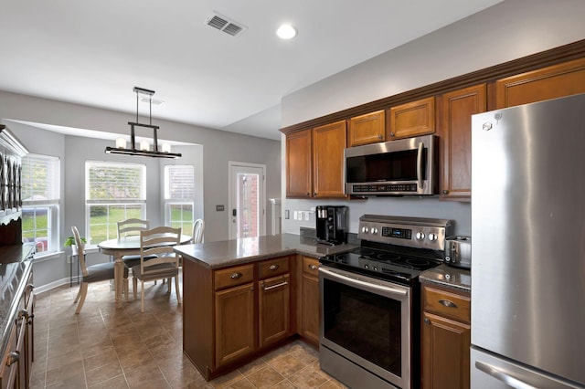 4047 Locerbie Cir, Spring Hill, TN 37174 - kitchen with appliances with stainless steel finishes, brown cabinets, a peninsula, decorative light fixtures, and recessed lighting