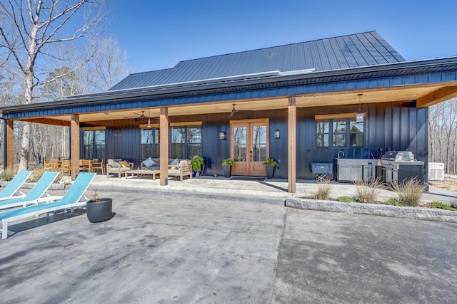 639 Piney Creek Rd, Hohenwald, TN 38462 - back of property featuring french doors, a patio, an outdoor living space, metal roof, and board and batten siding