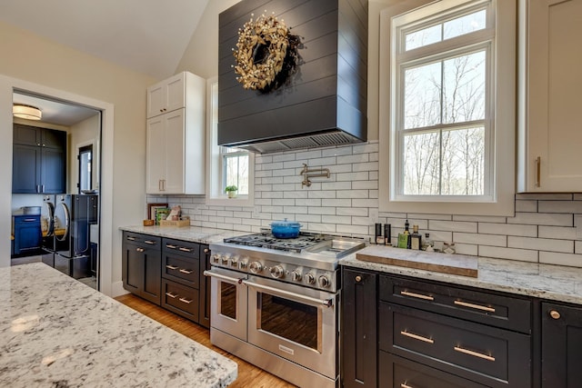 639 Piney Creek Rd, Hohenwald, TN 38462 - kitchen with double oven range, white cabinetry, decorative backsplash, premium range hood, and vaulted ceiling