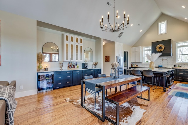 639 Piney Creek Rd, Hohenwald, TN 38462 - dining area with wine cooler, a chandelier, high vaulted ceiling, light wood-type flooring, and recessed lighting