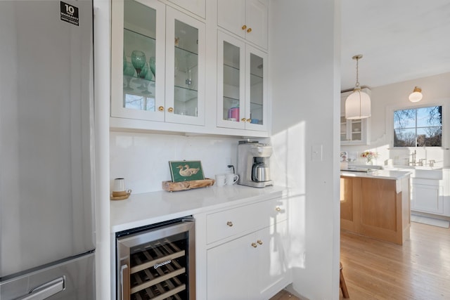 409 W 6th St, Columbia, TN 38401 - indoor dry bar with refrigerator, beverage cooler, light wood finished floors, and hanging light fixtures