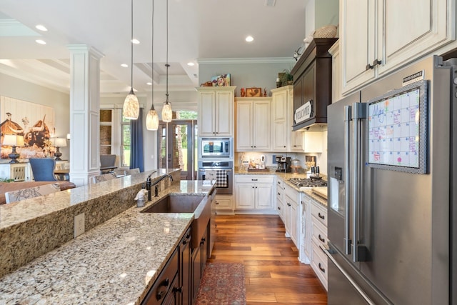 532 Tidwell Rd, Bon Aqua, TN 37025 - kitchen with stainless steel appliances, ornate columns, wood finished floors, a sink, and crown molding
