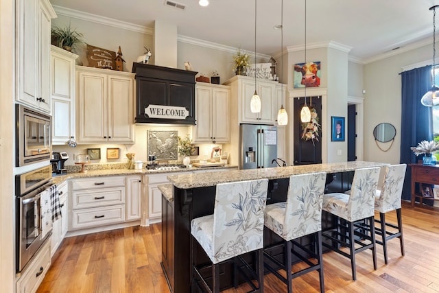 532 Tidwell Rd, Bon Aqua, TN 37025 - kitchen with appliances with stainless steel finishes, a kitchen breakfast bar, light wood finished floors, a center island with sink, and ornamental molding