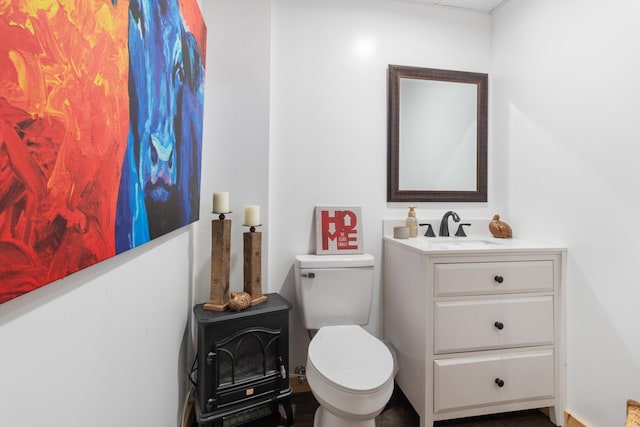 532 Tidwell Rd, Bon Aqua, TN 37025 - half bathroom featuring a wood stove, vanity, and toilet