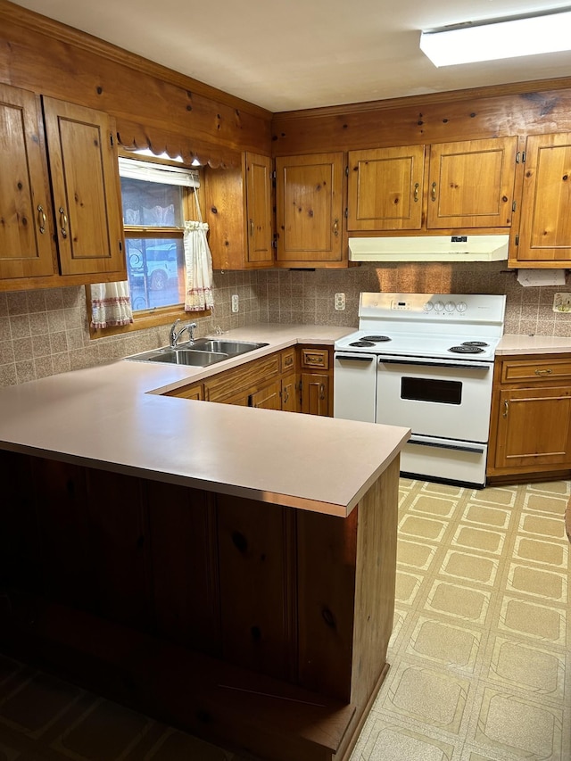 1409 Nashville Hwy, Columbia, TN 38401 - kitchen with under cabinet range hood, electric stove, a sink, brown cabinets, and a peninsula
