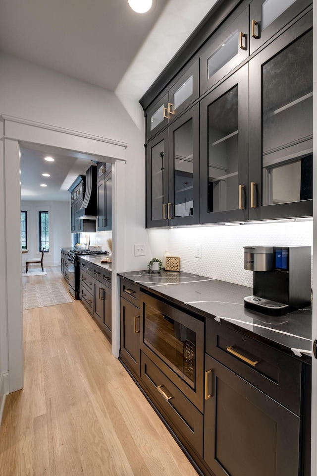 1050 Garton Rd, Burns, TN 37029 - bar with wall chimney range hood, black appliances, light wood-style floors, and backsplash
