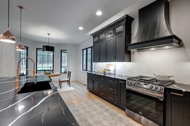 1050 Garton Rd, Burns, TN 37029 - kitchen featuring stainless steel range with gas stovetop, custom range hood, a sink, dark cabinetry, and light wood-type flooring