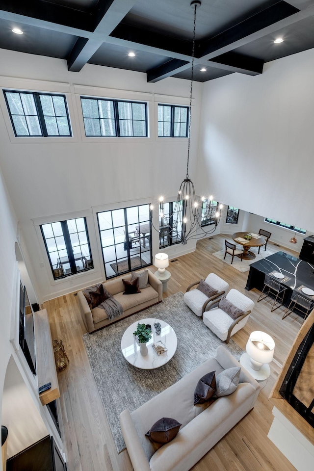 1050 Garton Rd, Burns, TN 37029 - living area featuring coffered ceiling, beam ceiling, wood finished floors, a chandelier, and plenty of natural light