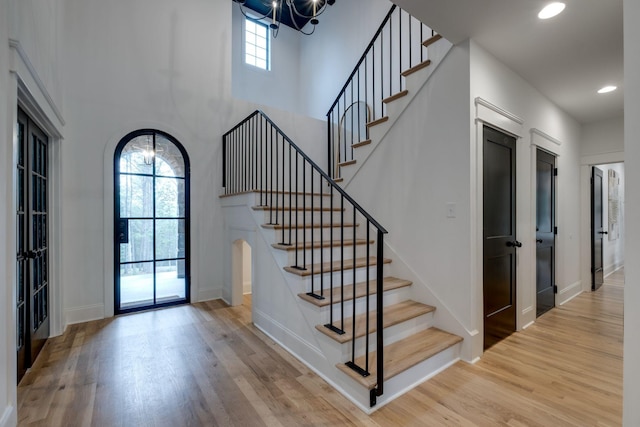 1050 Garton Rd, Burns, TN 37029 - staircase with a chandelier, wood finished floors, baseboards, recessed lighting, and arched walkways