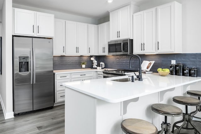 184 Primrose Ln, Gallatin, TN 37066 - kitchen featuring stainless steel appliances, a peninsula, a sink, white cabinets, and light countertops