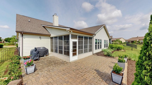 1106 Davidson Walk, Spring Hill, TN 37174 - back of property featuring a sunroom, a patio, a chimney, and a shingled roof