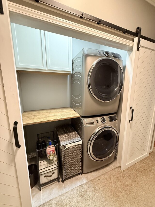 2415 Saint Andrews Dr, Murfreesboro, TN 37128 - washroom with stacked washer and clothes dryer, cabinet space, and a barn door