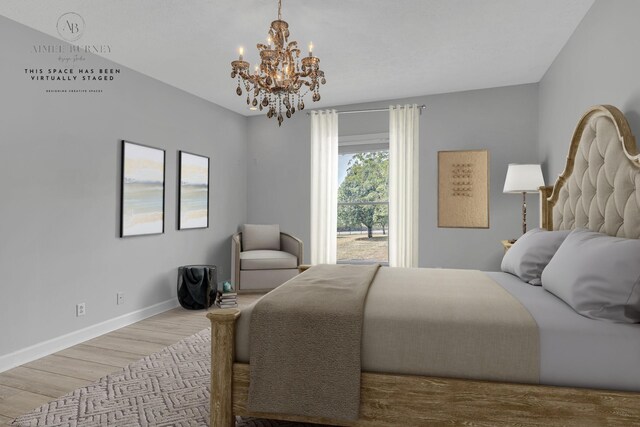 2103 Liebengood Rd, Goodlettsville, TN 37072 - bedroom with a chandelier, wood finished floors, and baseboards