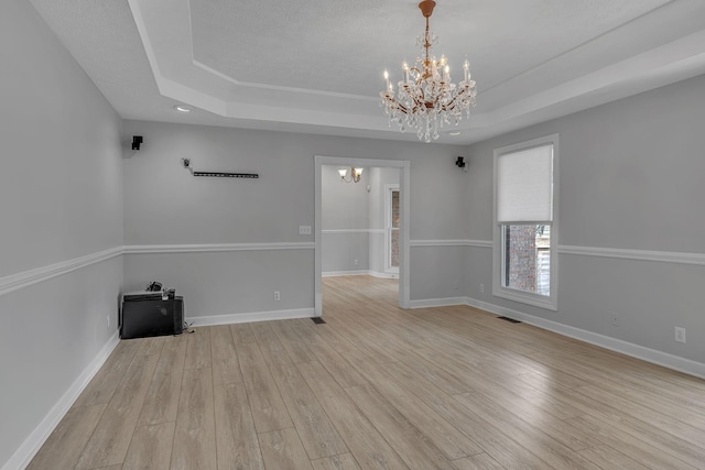 2103 Liebengood Rd, Goodlettsville, TN 37072 - spare room featuring a chandelier, a raised ceiling, and light wood finished floors