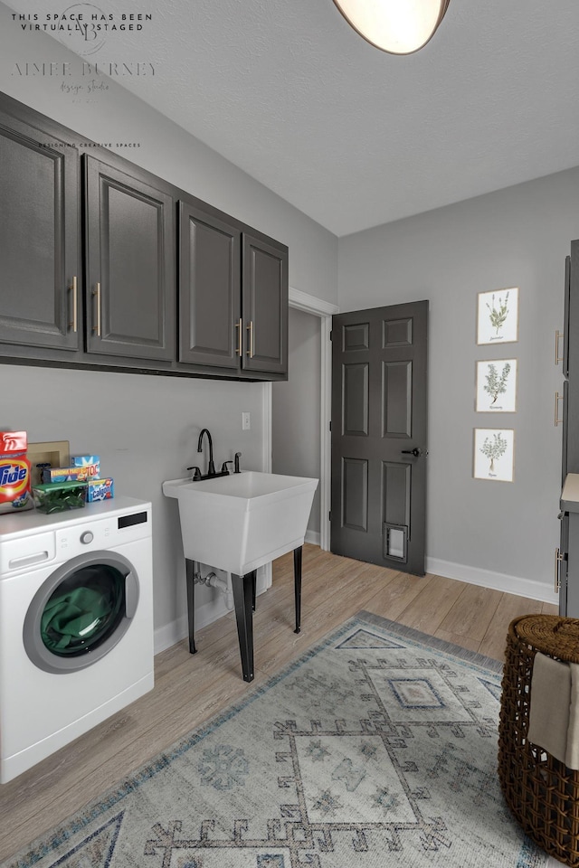 2103 Liebengood Rd, Goodlettsville, TN 37072 - laundry room featuring washer / clothes dryer, light wood finished floors, baseboards, and cabinet space