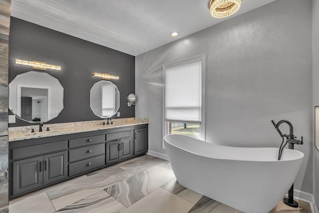 2103 Liebengood Rd, Goodlettsville, TN 37072 - bathroom with double vanity, a freestanding tub, and baseboards