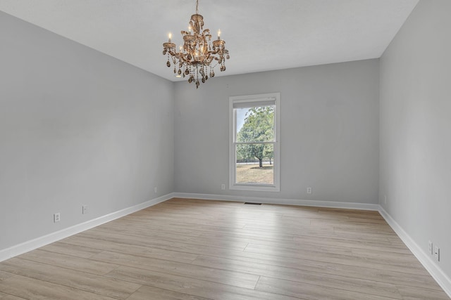 2103 Liebengood Rd, Goodlettsville, TN 37072 - empty room featuring a chandelier, light wood-style flooring, and baseboards