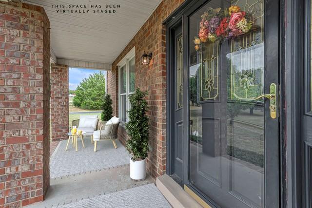 2103 Liebengood Rd, Goodlettsville, TN 37072 - doorway to property with covered porch and brick siding