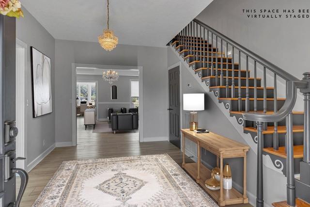 2103 Liebengood Rd, Goodlettsville, TN 37072 - foyer with a chandelier, stairway, wood finished floors, and baseboards