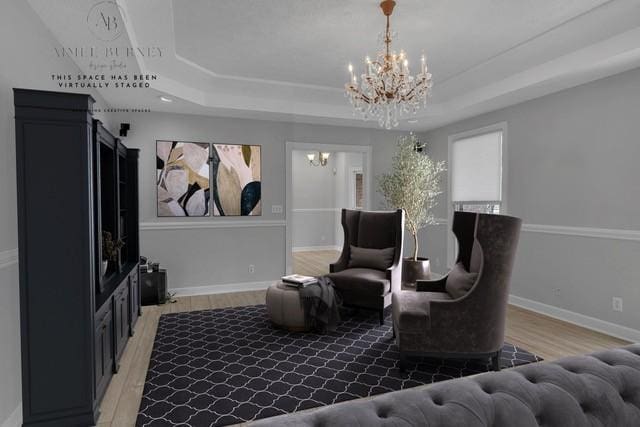 2103 Liebengood Rd, Goodlettsville, TN 37072 - living area featuring a chandelier, a tray ceiling, light wood finished floors, and baseboards