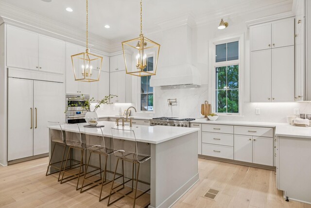 9314 Double Run Ct, College Grove, TN 37046 - kitchen with paneled built in refrigerator, crown molding, light wood-style floors, an island with sink, and white cabinetry