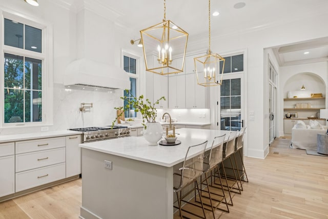 9314 Double Run Ct, College Grove, TN 37046 - kitchen with crown molding, custom exhaust hood, a chandelier, white cabinetry, and backsplash
