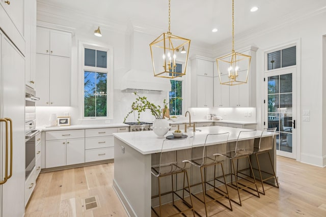 9314 Double Run Ct, College Grove, TN 37046 - kitchen featuring a chandelier, light wood-style floors, ornamental molding, light countertops, and white cabinetry