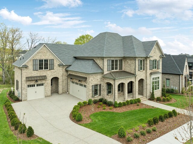 9314 Double Run Ct, College Grove, TN 37046 - french provincial home featuring a standing seam roof, concrete driveway, a front lawn, brick siding, and a garage