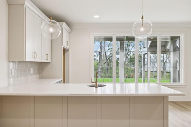 9314 Double Run Ct, College Grove, TN 37046 - kitchen with a sink, decorative backsplash, white cabinetry, hanging light fixtures, and ornamental molding