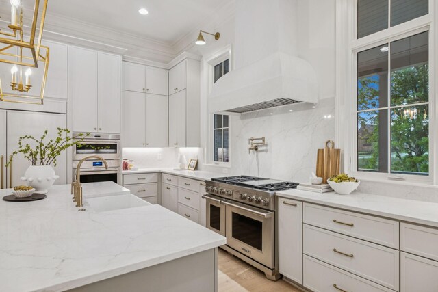 9314 Double Run Ct, College Grove, TN 37046 - kitchen with stainless steel appliances, white cabinetry, decorative light fixtures, tasteful backsplash, and light stone counters