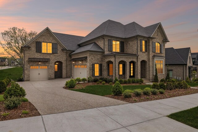 9314 Double Run Ct, College Grove, TN 37046 - french country home featuring concrete driveway, brick siding, a yard, and a garage