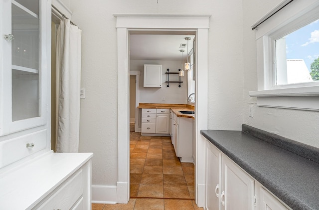 213 Maple St, Bell Buckle, TN 37020 - hallway featuring a sink, a textured wall, light tile patterned flooring, and baseboards