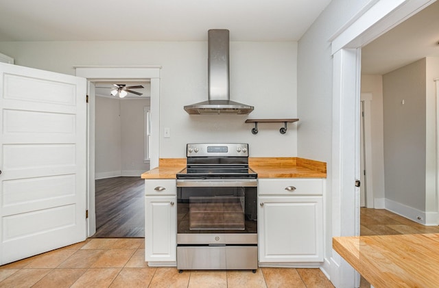 213 Maple St, Bell Buckle, TN 37020 - kitchen featuring electric stove, wall chimney exhaust hood, butcher block countertops, and white cabinets