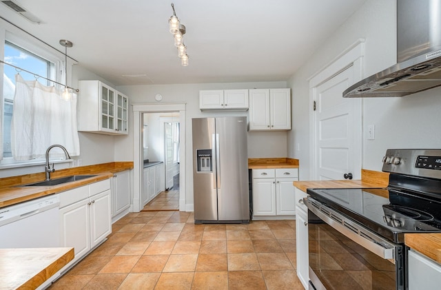 213 Maple St, Bell Buckle, TN 37020 - kitchen featuring appliances with stainless steel finishes, wall chimney range hood, butcher block countertops, and a sink