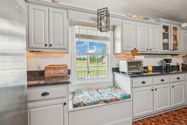 834 Union Camp Rd, Lafayette, TN 37083 - kitchen with freestanding refrigerator, glass insert cabinets, dark stone counters, a textured ceiling, and white cabinetry